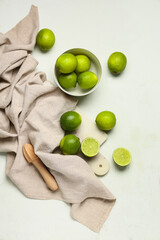 Wall Mural - Bowl and cutting board with fresh ripe limes on white background