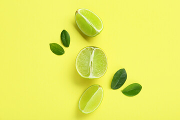 Wall Mural - Cut fresh ripe lime and leaves on green background
