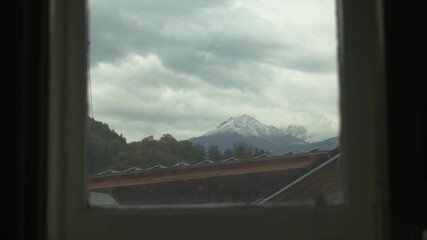 Wall Mural - Peaceful time-lapse of clouds drifting outside a modern window in Innsbruck. Captures quiet, reflective indoor moments with natural light.