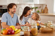 © Stockphotodirectors - A cheerful family spends time together in a sunny kitchen. Parents and their young child prepare food, sharing smiles and laughter as they bond over cooking and enjoying each other's company.