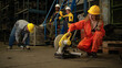 © Wosunan - Team of factory workers wearing safety uniforms and helmets operating power tools
