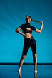© Bliss - Seductive young model poses in stylish black latex outfit in vibrant studio setting