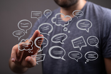 A man touching digital speech bubbles, representing communication, connection, and online networks. Ideal for messaging concepts.