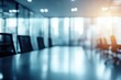 © Nice Seven - A blurred view of a modern conference room with a long table and chairs, illuminated by soft lighting, creating a professional atmosphere.