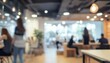 © Studicon - Blurred image of a modern office with people working at desks and a bright interior