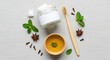 © Bening - Overhead view natural toothpaste ingredients including mint, cloves, star anise, and coconut oil with bamboo toothbrush