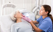 © JackF - Young female cosmetologist in gloves examining face skin of elderly female client before beauty procedure in spa center indoors