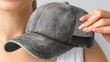 © NguyenThi - Modern gray baseball cap held by a woman with pink manicured nails, perfect for summer style and casual fashion, ideal for outdoor adventures