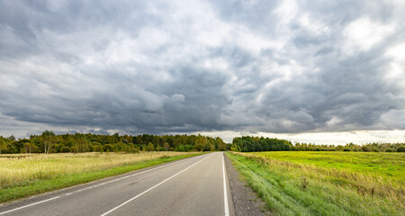 Wall Mural - Road with a cloudy sky in the background