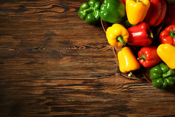 Wall Mural - Bowl and plate with fresh colorful bell peppers on wooden background