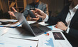 © crizzystudio - Business people analysing financial data using laptop and documents