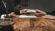 © crizzystudio - Client giving money to lawyer for legal services