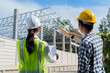 © crizzystudio - Engineers discussing building plans at active construction site
