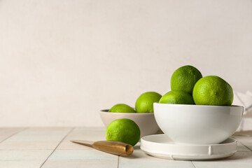 Wall Mural - Bowls with fresh ripe limes on white tile table