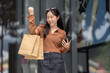 © crizzystudio - Happy woman celebrating shopping success holding smartphone