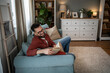 © Migma_Agency - Young man relaxing on sofa enjoying a good book