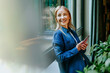 © Westend61 - Businesswoman in denim shirt smiling and messaging in modern office
