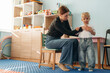© standret - Woman is sitting and checking the boy. Preschool child with teacher during developmental activities in a playroom