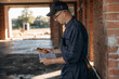 © standret - Builder is working on construction site, unfinished building