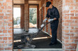 © standret - Process of leveling the concrete on the floor. Builder is working on construction site, unfinished building
