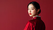 © A2Z AI  - Elegant portrait of a woman with traditional Asian attire against a deep red backdrop, showcasing refined beauty and cultural grace.