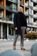 © Dmytro Hai - Full length of elegant man in coat looking at camera on city street