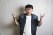 © yashis007 - Confused Asian Man with Denim Shirt Expressing Frustration and Bewilderment