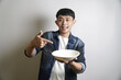 © yashis007 - Enthusiastic man pointing to a clean empty bowl with a cheerful expression