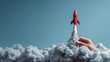 © St - Red rocket launching from a hand