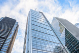 Low angle view of glass office skyscrapers against blue sky with clouds on a winter morning
