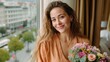 © irina - Woman with a bouquet of flowers smiles by the window in a city hotel during the day