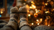 © KristinaEjevika - Close-up of legs wearing cozy knitted socks resting near Christmas tree with blurred warm bokeh lights in background