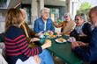 © CarlosBarquero - Happy group of senior people laughing and enjoying coffee sitting at cafeteria bar table. Retired generation community friends having fun gathered on terrace eating breakfast and drinking hot beverage
