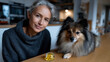 © Milos - An elegant senior woman sitting with her fluffy dog near natural supplements, highlighting the importance of health and wellness in the lives of pets and their owners.