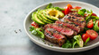 © Tasawar - Juicy grilled steak with sliced avocado and fresh greens for a vibrant, protein-packed lunch that's both healthy and delicious on a modern plate