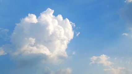 Wall Mural - Clear blue sky filled with fluffy white cumulus clouds. Cumulus clouds floating peacefully in a bright blue sky. Scenic view of white clouds drifting in the blue sky.