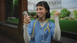 © Krakenimages.com - Woman doctor with stethoscope pumps fist while holding smartphone at pisa tower building; triumph success.