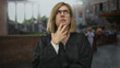 © Krakenimages.com - Woman judge in robe with hand on chin in sunlit roman ruins building; thoughtful pondering doubt introspection.