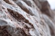 © Akbar Fillah - Closeup shows weathered white rock surface with dark brown striations and pitted texture in sharp focus