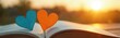 © Oleksandr - Two colorful heart bookmarks sit in open book. Golden sun shines bright in blurry background, casting light on pages. Creates warm, romantic, quiet reading moment outside. Suggests love of stories,
