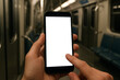 © Ruth - A smartphone mockup held in hand inside a subway train.