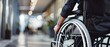 © GoStudio - Closeup view of a person in a wheelchair moving along office hallway. Concept of accessibility, inclusion, disability, rehabilitation, independence, healthcare and equal opportunity in workplace.
