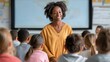 © liliyabatyrova - A joyful teacher stands in front of her class, smiling as she connects with students. Kids are engaged, eager to learn and participate in the lesson