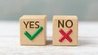 © Sutasinee - A wooden cube, green check mark cube and red cross mark cube on white background, Yes and No, concept decide to choose a vote. Yes or No decisions indicating confirmation or correctness.