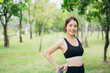 © NewSaetiew - Young woman practicing yoga and stretching outdoors in a green park, wearing black sportswear. Healthy lifestyle, fitness training, and relaxation concept in a peaceful natural environment.