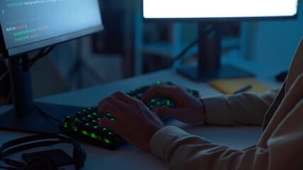 Professional male programmer coding software late at night in cyber office with multiple monitors and blue ambient lighting, symbolizing focus, innovation, and digital technology workflow.