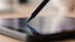 © Intie - A close-up shot of a digital pen touching a tablet screen. Focus is sharp