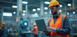© Lubov - Engineer wearing helmet in industrial factory monitors production using laptop. Technical expert with safety gear inspects manufacturing. Professional worker at a plant uses computer.