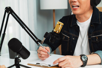 Smiling radio influencer host wearing headphone interviewing woman speaker sharing information to listeners on social media online website live streaming channel at morning at studio record. Infobahn.