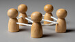 © Somphone - Connected Peg People: A symbolic representation of a collaborative network, with wooden peg people joined by interconnected cords, emphasizing the significance of teamwork and unity.
